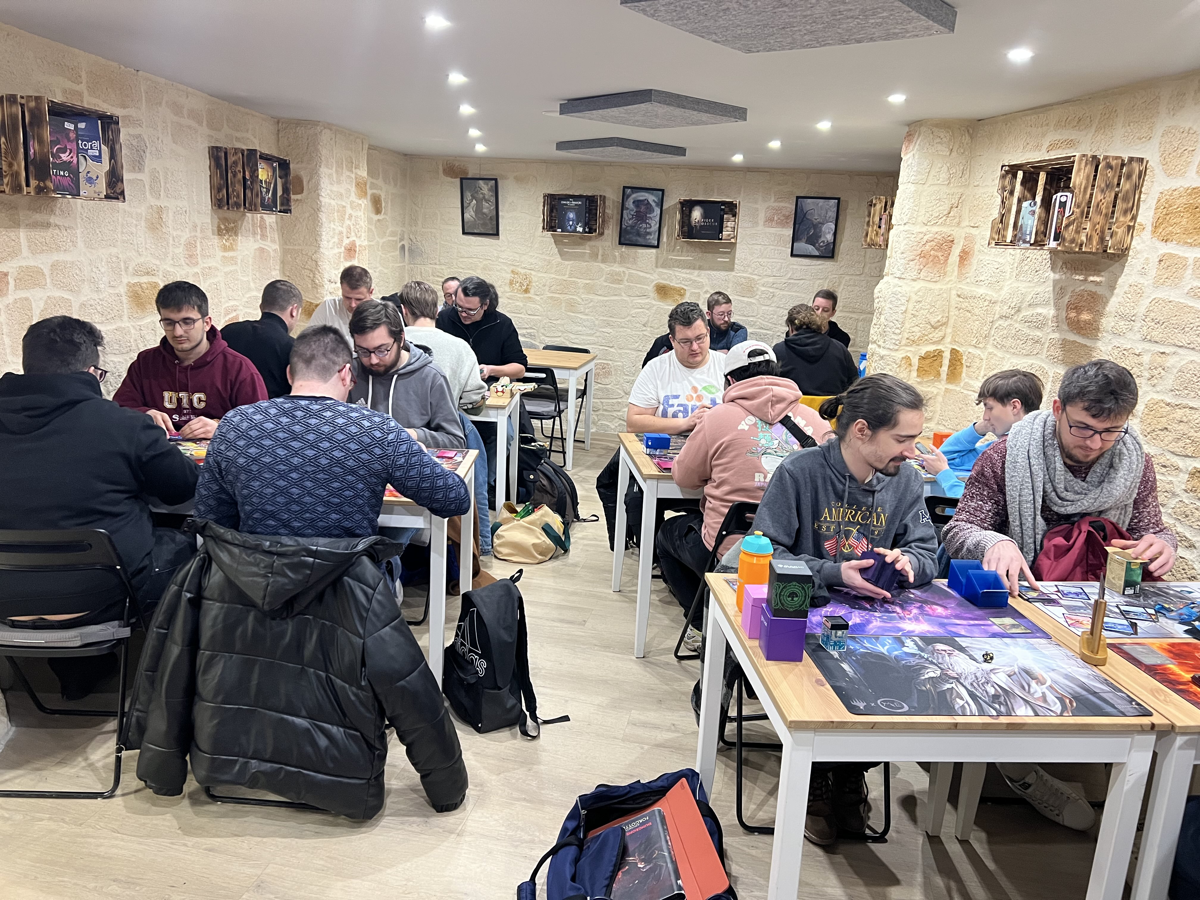 Des joueurs qui font des parties de TCG dans l'Antre de Mondes